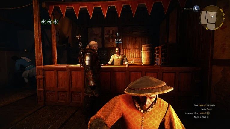 Stjepan derrière le comptoir de l’auberge de l’Alchimie à Oxenfurt dans The Witcher 3